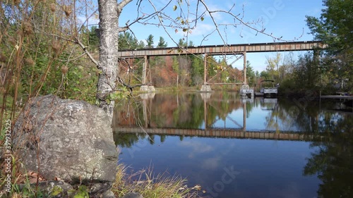 Left to right pan by a river with train bridge photo