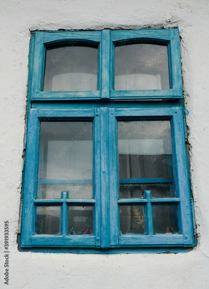 Fototapeta premium old blue windows to a house painted white