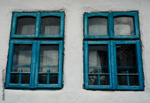 old blue windows to a house painted white