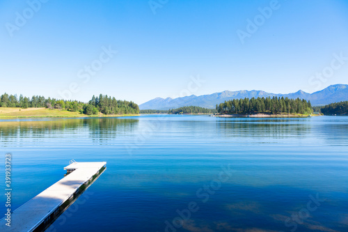 A calm beautiful scenic lake high in the Mountains of Montana called Echo Lake. A landscape photo that shows the beauty of Montana. Blue serene waters with a boat dock