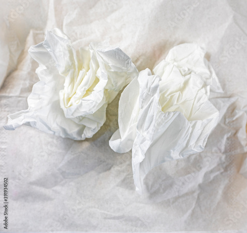 crumpled white napkins lie on a crumpled table napkin, elongated format