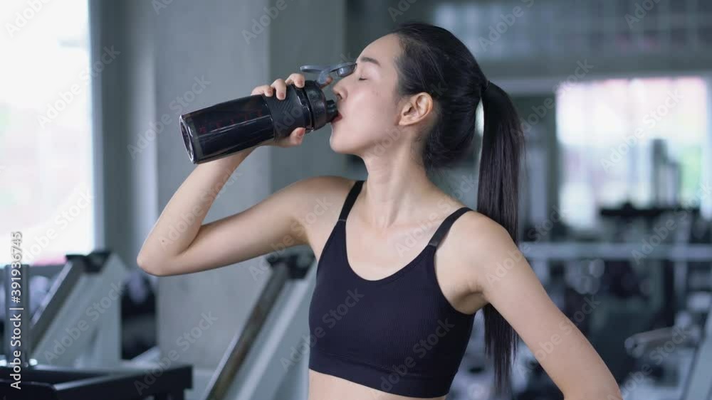 Fitness woman eagerly drinking water from a bottle after training in the gym 4k resolution Fitness woman eagerly drinking water from a bottle after training in the gym 4k resolution