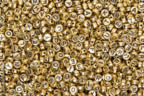 Metallic gold English alphabet beads background