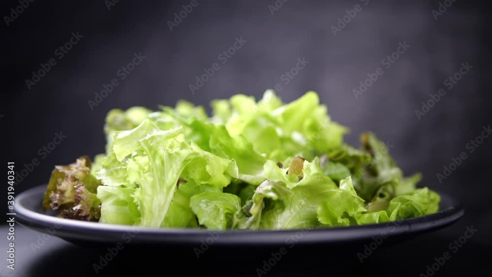 Fresh salad rotate in slow motion on black background. Vegetable salad for healthy eating Fresh salad rotate in slow motion on black background. Vegetable salad for healthy eating
