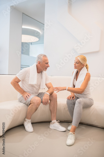 A man and a woman in sportswear talking after a workout