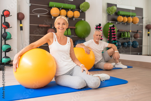 Middle-aged couple siting on the mat with fitballs photo