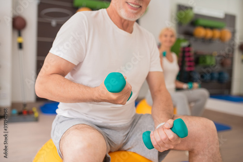 Close up picture of a man with dumbbells