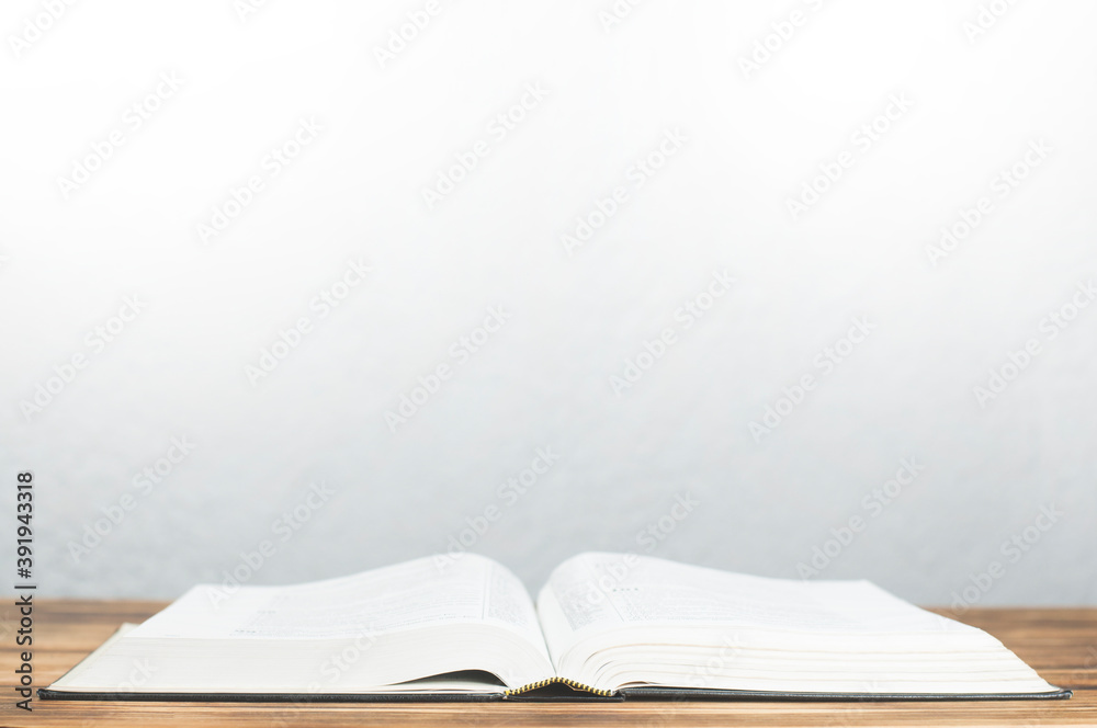 Fototapeta premium Open book Bible. On a wooden table. Knowledge discovery and study concept