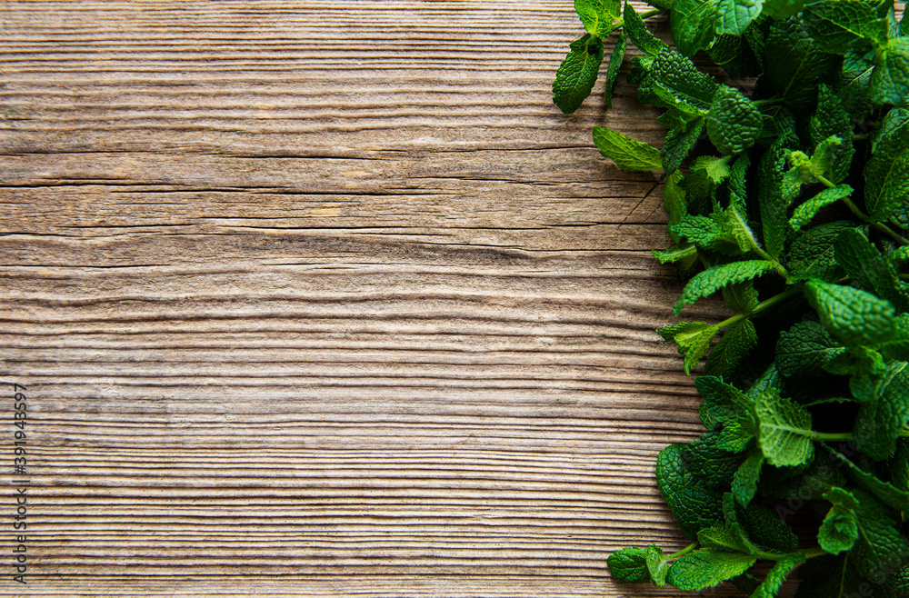 Fresh mint leaves on old wooden background Fresh mint leaves on old wooden background