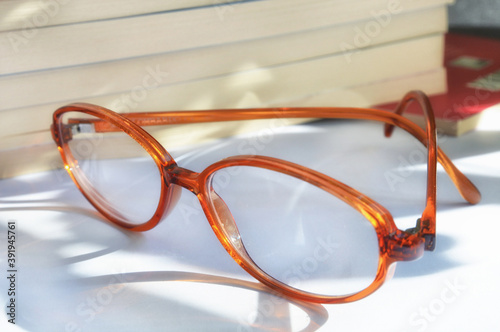 The elegant eyeglasses are nearby the several books. Reading concept.