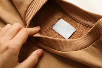 Female hand hold blank stylish sweatshirt, close up