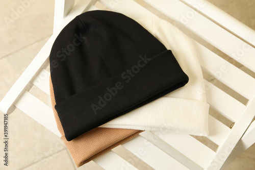 Foto Three stylish beanies on wooden chair, top view