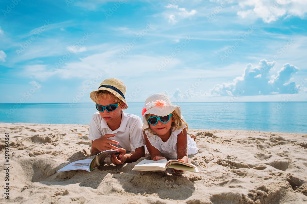 boy and girl read books on beach, family vacation