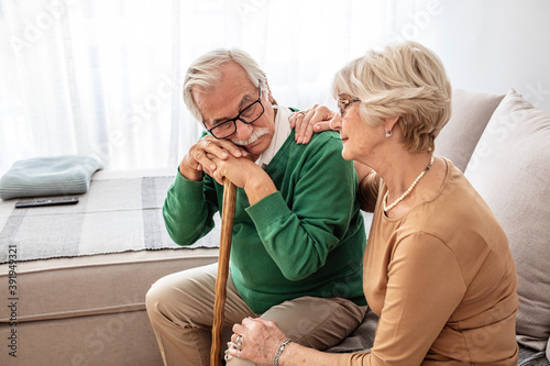 Portrait of woman hugging senior husband with walking stick at home. Shot of a senior woman comforting her husband. Always supporting one another