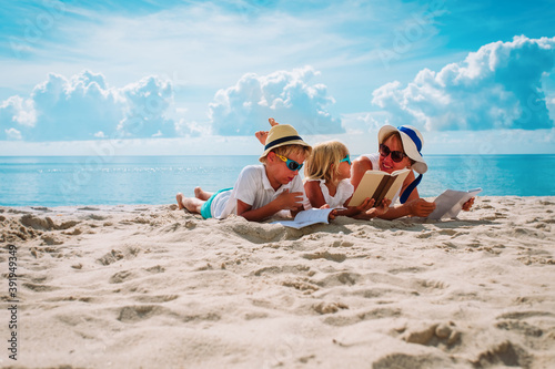 Fototapeta Naklejka Na Ścianę i Meble -  mother with son and daughter reading books at beach