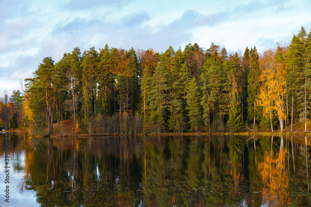 Autumn colorful foliage over lake with beautiful woods in green and yellow color. Autumn colorful foliage over lake with beautiful woods in green and yellow color.