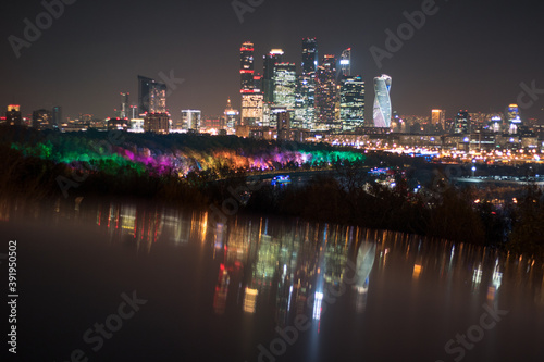 Die moderne Skyline Moskaus bei Nacht, in bunten Farben strahlend und reflektierend © Tarek