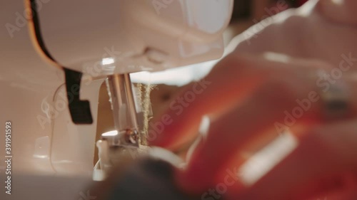 Close up of a working sewing machine: fashion designer sews clothes