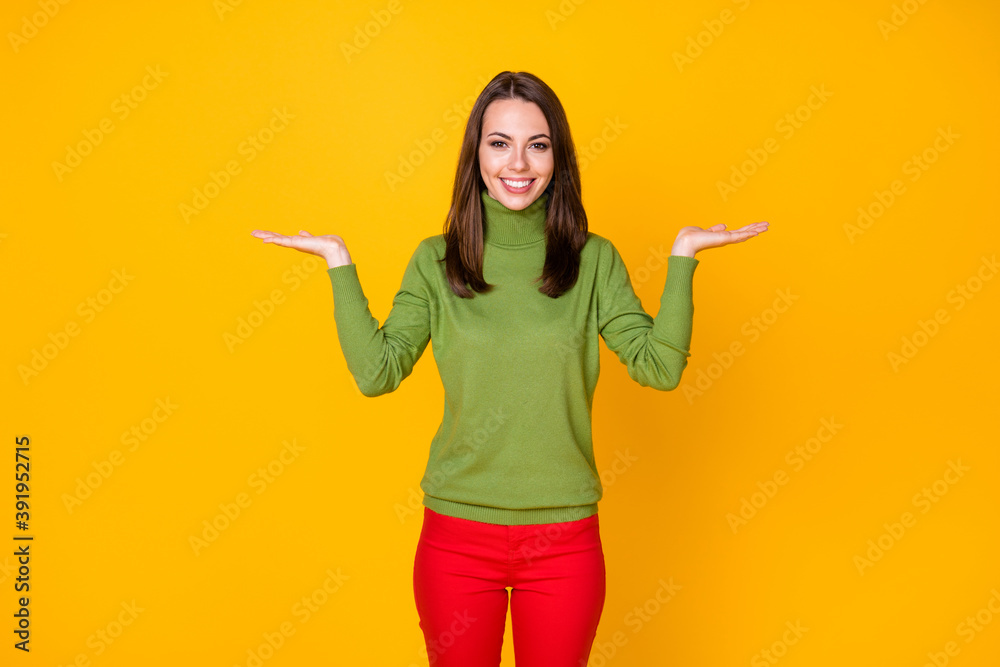 Portrait of pretty cheerful girl holding on two palms copy space offer isolated over bright yellow color background Portrait of pretty cheerful girl holding on two palms copy space offer isolated over bright yellow color background