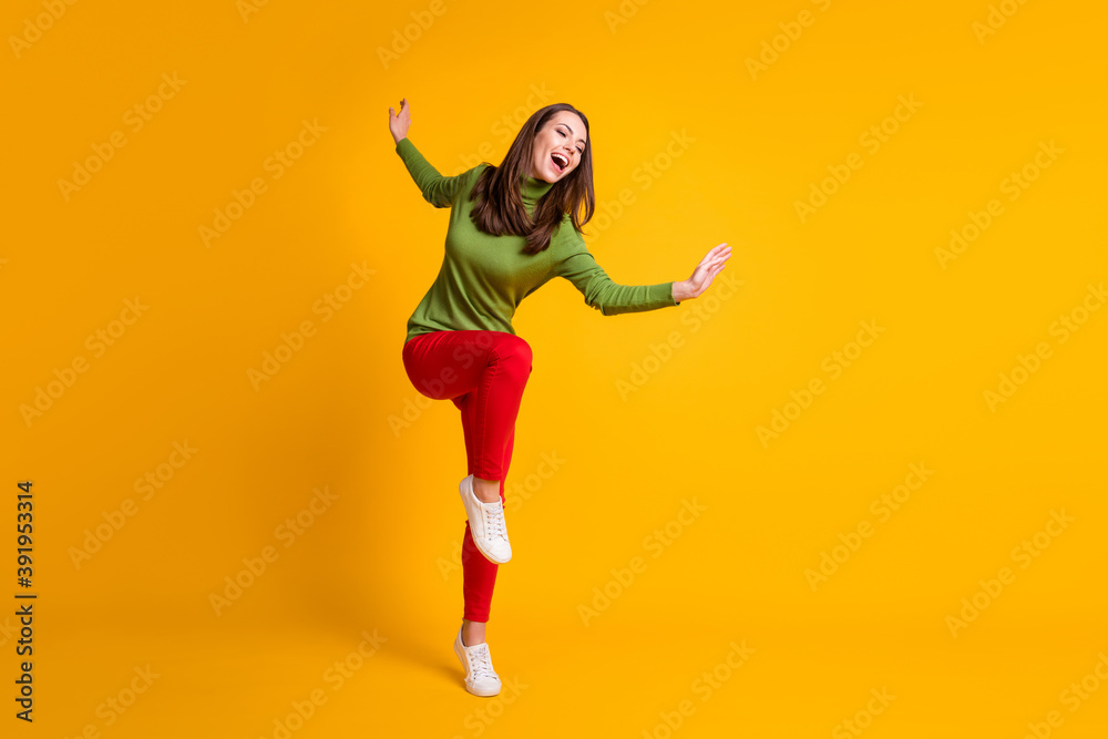 Full length body size view of pretty ecstatic overjoyed cheery girl jumping having fun dancing isolated bright yellow color background Full length body size view of pretty ecstatic overjoyed cheery girl jumping having fun dancing isolated bright yellow color background