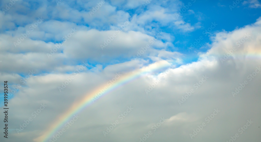 Front view of rainbow background on a cloudy sky