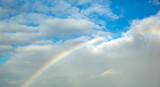 Front view of rainbow background on a cloudy sky