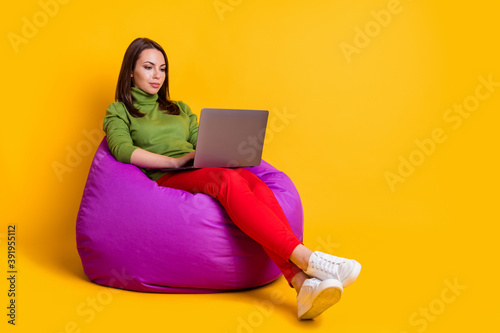 Photo of attractive lady sit cozy bean bag work notebook wear green sweater pants shoes isolated yellow color background