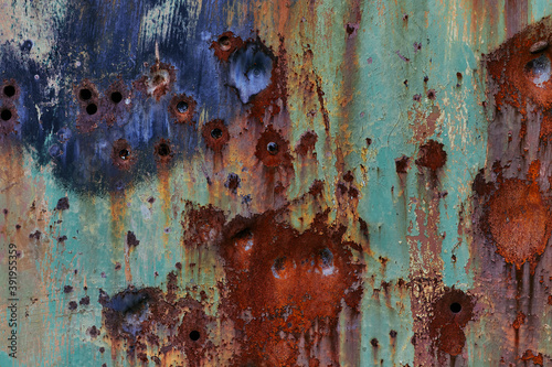 Texture of metal with dents and rust. Grunge metal with green paint and gunshot holes. Abstract rusty metal background for design and photoshop.