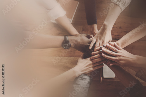 Hands joined over wooden table