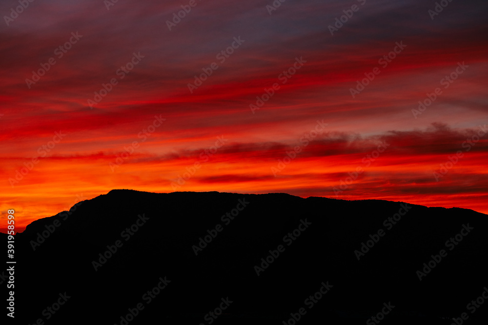 A fiery red sunset over dark mountains. A saturated scarlet sunset and clouds. Sunset sky for Photoshop. A fiery red sunset over dark mountains. A saturated scarlet sunset and clouds. Sunset sky for Photoshop.