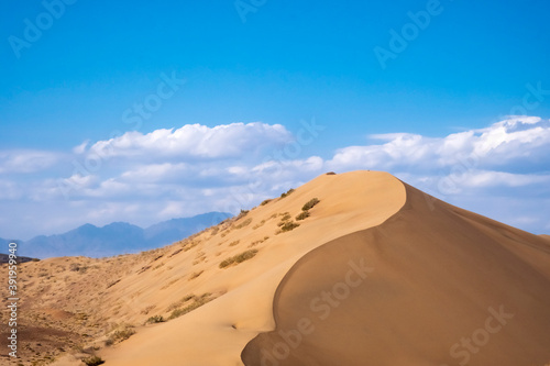 Sand dunes with clouds backgorund. Natural landscape. Altyn-Emel singing dunes or barkhan. Altyn-emel national park in Kazakhstan. Tourism travel in Kazakhstan concept.