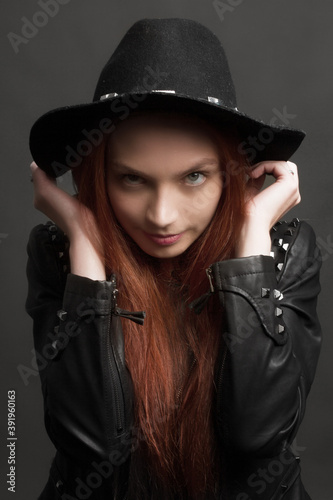 young ginger rock style woman in black hat and leather jacket