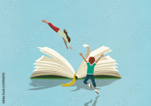 Exuberant boy watching girl dive into book
 photo