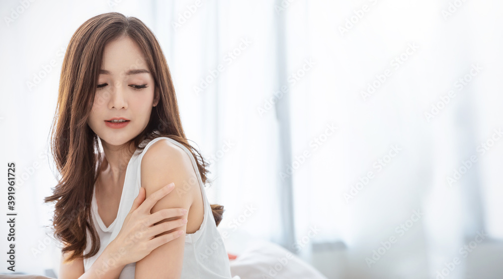 Portrait of beauty  smiling asian woman applying a lotion to her arm skin during her morning routine. Cute asian girl. Skincare body lotion, beauty clinic skincare spa, indoors woman lifestyle concept