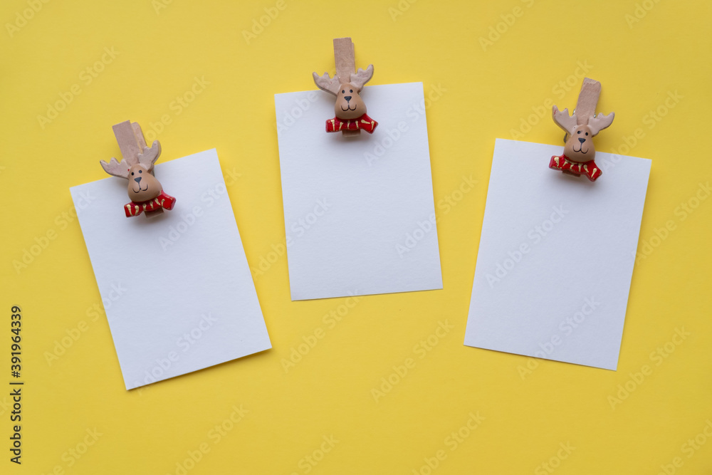 Christmas cards mockup on clothespins santa claus on a yellow background.