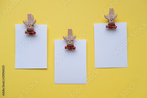 Obraz na płótnie Christmas cards mockup on clothespins santa claus on a yellow background w salonie