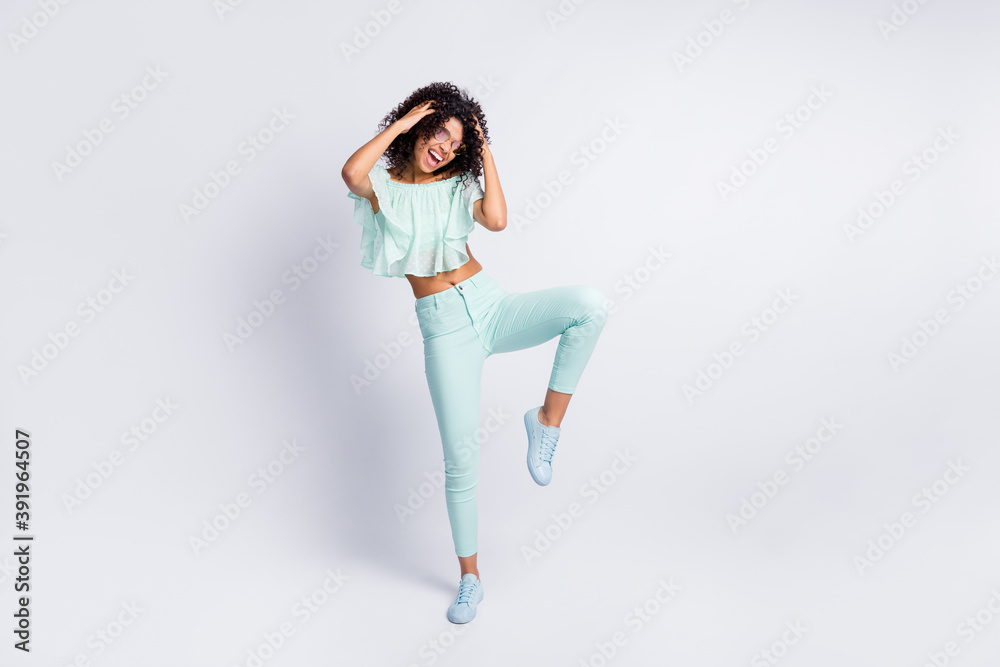 Full length body size photo of young beautiful female dancing in sunglass isolated on grey color background