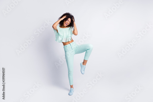 Full length body size photo of young beautiful female dancing in sunglass isolated on grey color background