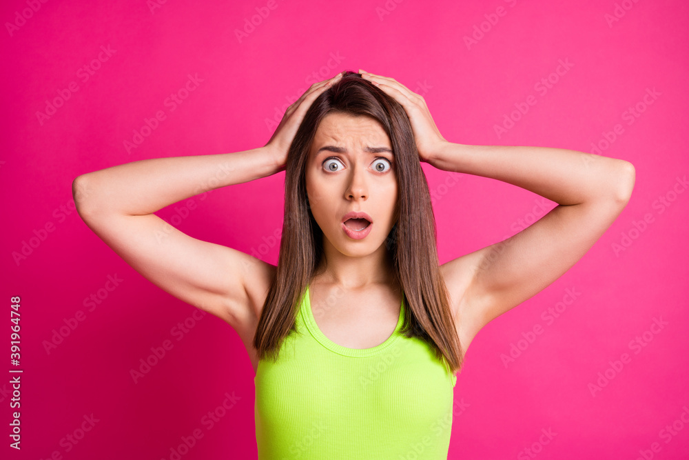 Obraz premium Photo of cute amazed young lady open mouth hands head wear lime top isolated on vibrant pink color background