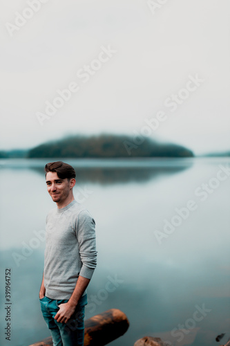 Portrait of young male model on a rainy day with a beautiful lake in the background