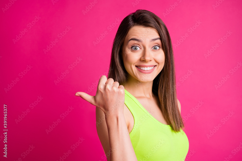 Photo of funny student lady direct thumb empty space shiny white smile wear green singlet isolated bright pink color background Photo of funny student lady direct thumb empty space shiny white smile wear green singlet isolated bright pink color background