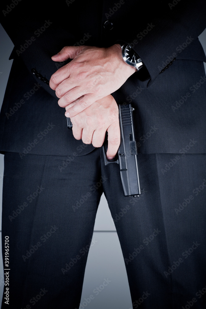 Detail photo of caucasian man in dark suit with a hand gun, bodyguard. - obrazy, fototapety, plakaty 