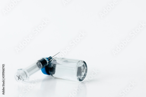 medical syringe and ampoule on white background. copy space.
