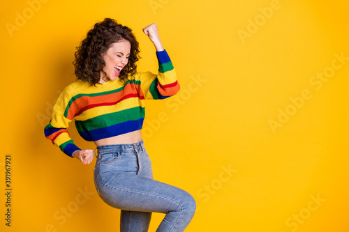 Profile photo of amazed careless lady raise arm scream wear striped pullover denim jeans isolated vibrant yellow color background
