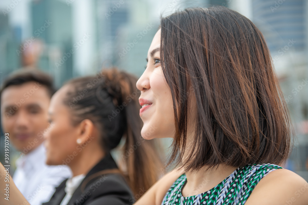 Three asian young friends standing outdoor looking at the city skyline. Street life of two girls and one boy Three asian young friends standing outdoor looking at the city skyline. Street life of two girls and one boy