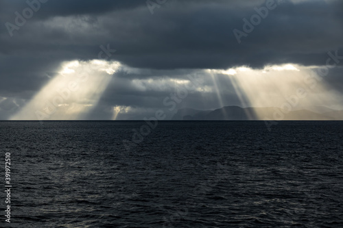 Dark clouds over the islands and ocean with ray lights