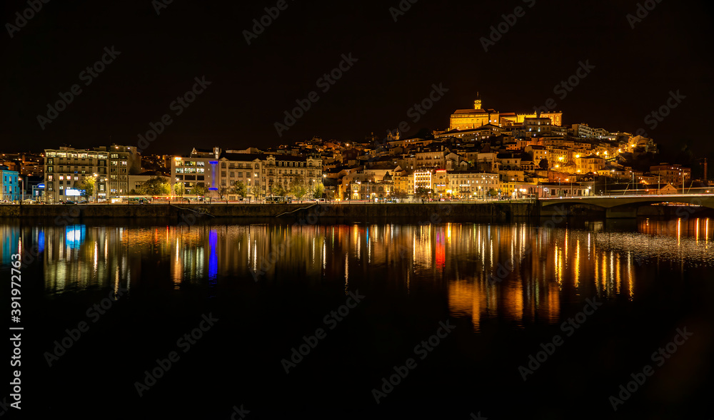 Coimbra à noite com reflexos das luzes no Rio Mondego