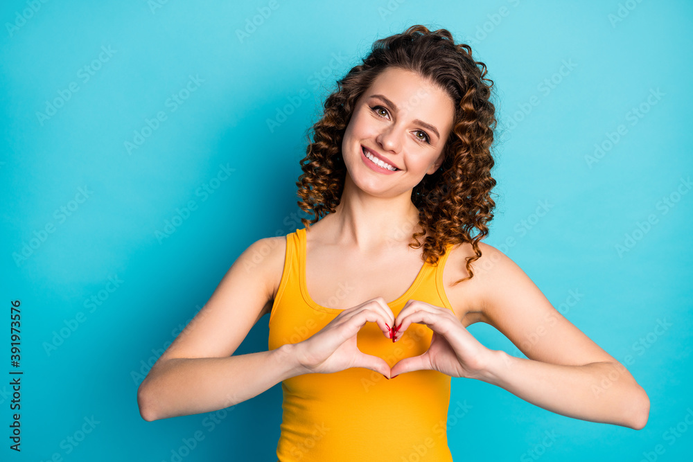 Photo of pretty ginger student girl toothy smiling romantic fingers heart shape wear yellow tank-top isolated blue color background