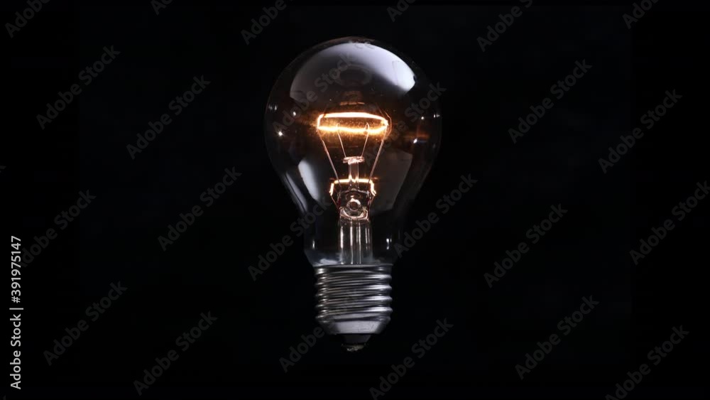 Light bulb hovers and shines slowly on black background. New idea