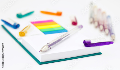 Various colored pencils, paper, notes on white background.